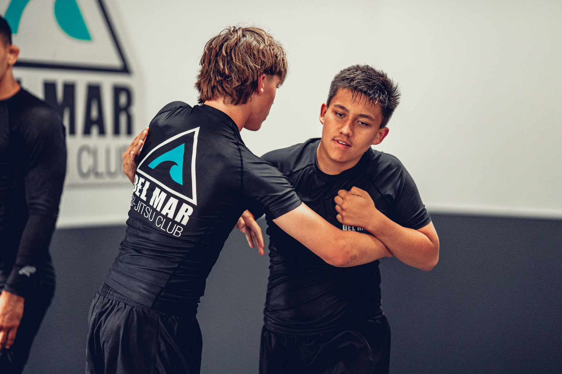 Two youth students concentrating while drilling a No-Gi Jiu-Jitsu technique